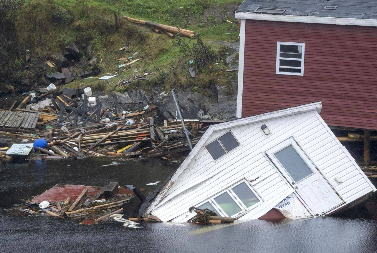 Buildings sit in the water along the shore following hurricane Fiona in Rose Blanche-Harbour Le Cou, N.L. on Tuesday September 27, 2022. The parliamentary budget watchdog says climate change has already begun to hurt the Canadian economy. THE CANADIAN PRESS/Frank Gunn
