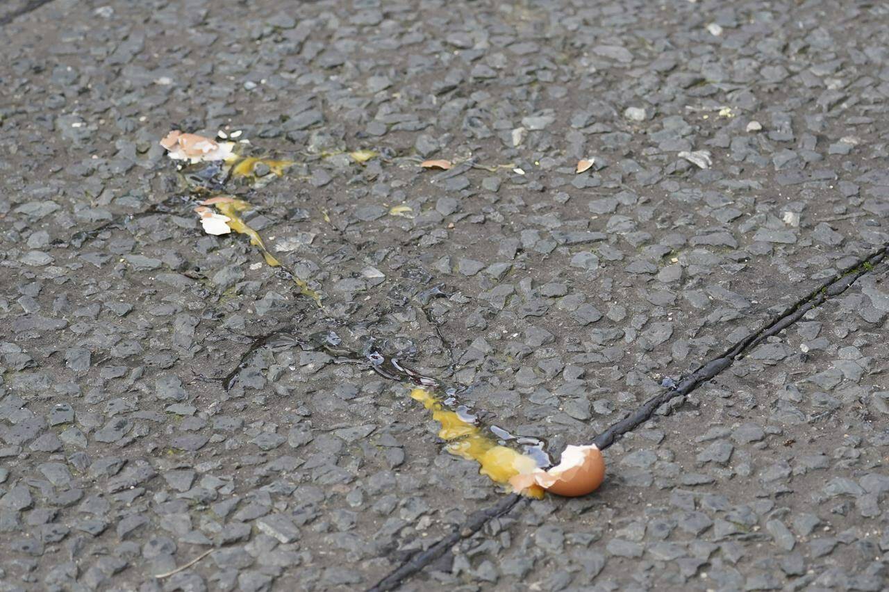 A broken egg is seen on the street after it was thrown at Britain’s King Charles III and the Queen Consort as they arrived for a ceremony at Micklegate Bar, where the Sovereign is traditionally welcomed to the city, in York, England, Wednesday Nov. 9, 2022. (Jacob King/PA via AP)