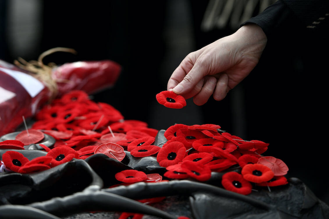 People lay poppies on the Tomb of the Unknown Soldier at the National War Memorial after the National Remembrance Day Ceremony in Ottawa, on Friday, Nov. 11, 2022. THE CANADIAN PRESS/Justin Tang