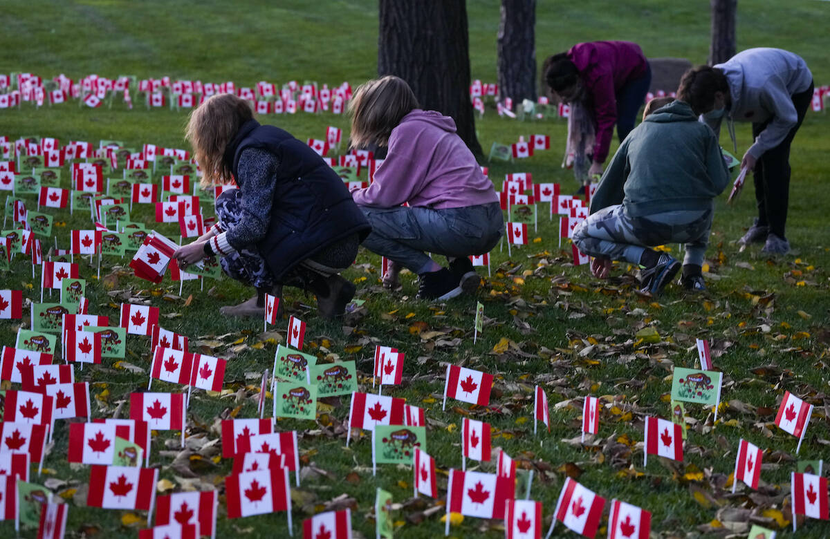 People place thousands of Canadian flags and Indigenous flags are planted for Remembrance Day at Sunnybrook Hospital in Toronto on Wednesday, November 10, 2021. THE CANADIAN PRESS/Nathan Denette