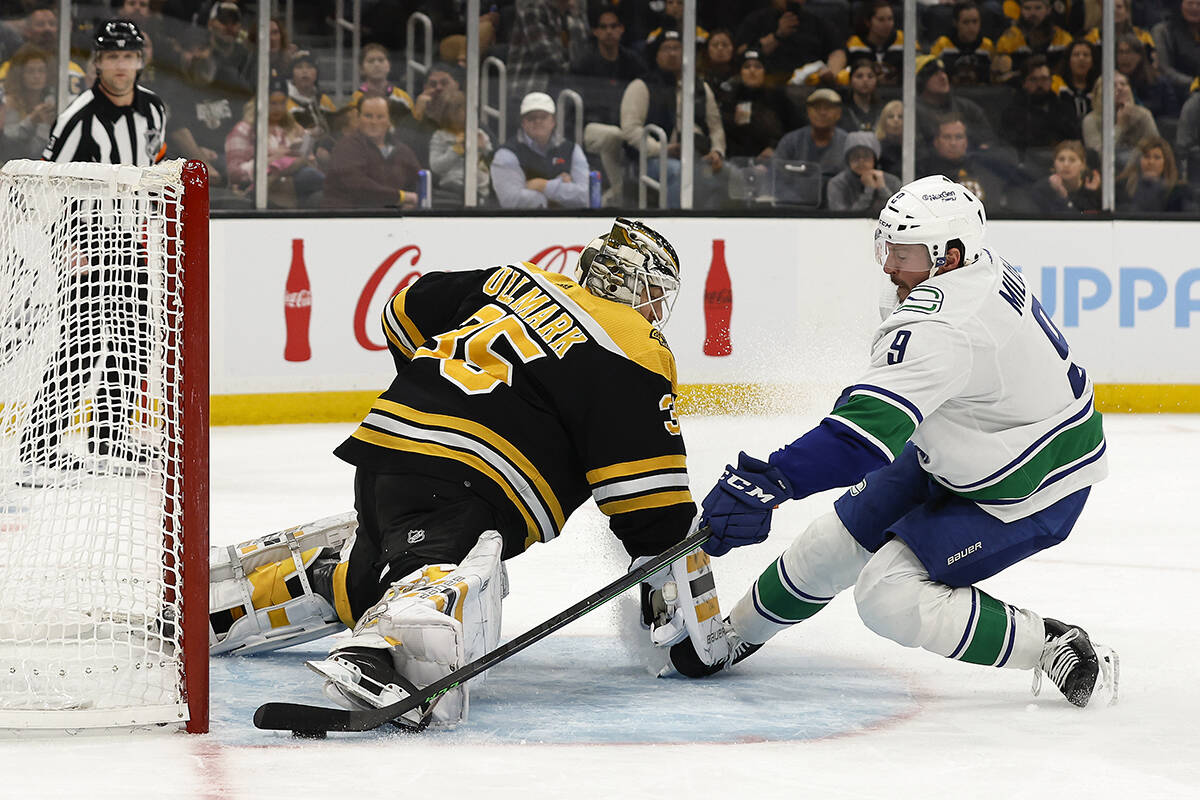 Vancouver Canucks’ J.T. Miller, right, scores against Boston Bruins goaltender Linus Ullmark, left, during the first period of an NHL hockey game Sunday, Nov. 13, 2022, in Boston. (AP Photo/Winslow Townson)