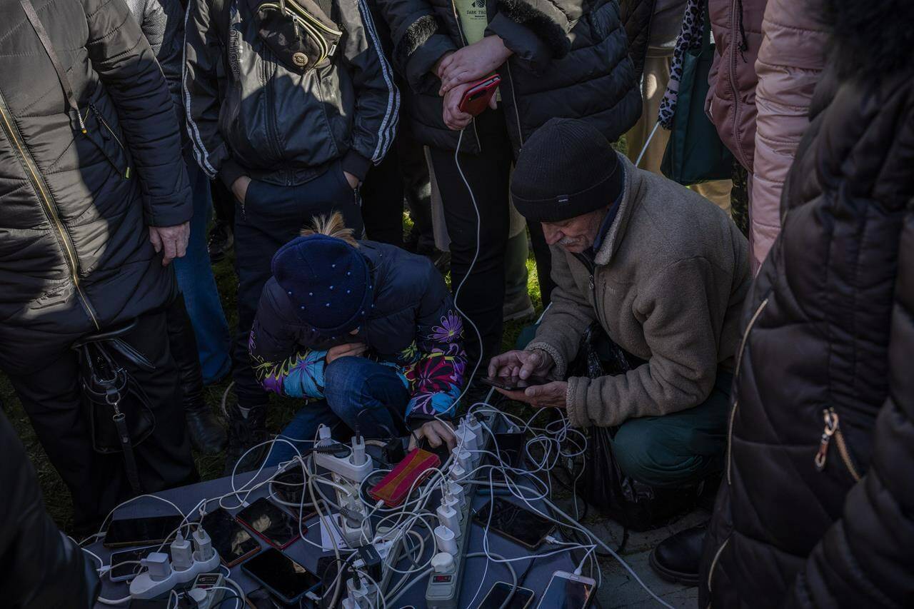 Residents gather next to an internet hotspot in Kherson, southern Ukraine, Monday, Nov. 14, 2022. The retaking of Kherson was one of Ukraine’s biggest successes in the nearly nine months since Moscow’s invasion. (AP Photo/Bernat Armangue)