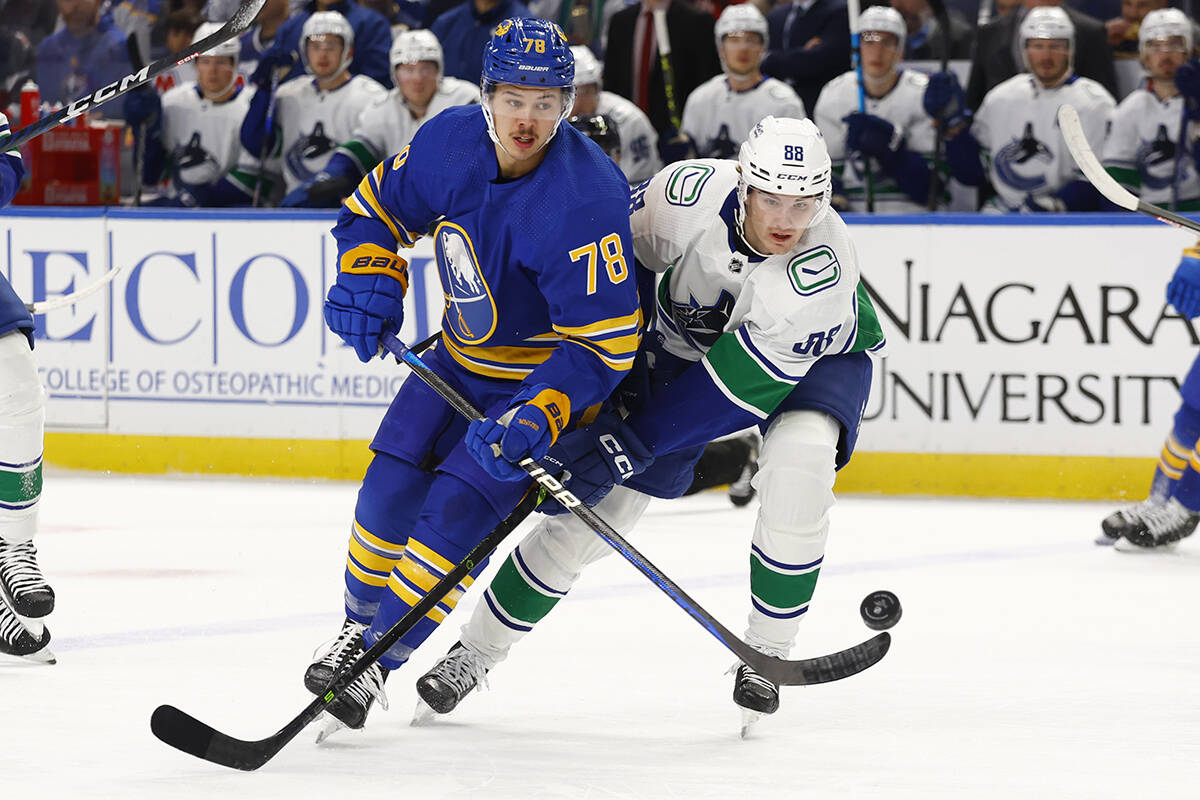 Buffalo Sabres defenceman Jacob Bryson (78) and Vancouver Canucks centre Nils Aman (88) battle for the puck during the first period of an NHL hockey game, Tuesday, Nov. 15, 2022, in Buffalo, N.Y. (AP Photo/Jeffrey T. Barnes)