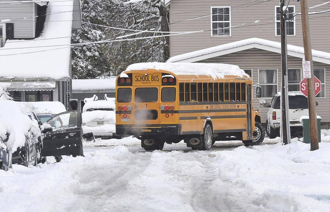 An Erie School District bus turns on Old French Road from East 33rd Street in Erie, Pa. on Nov. 17, 2022, following the region’s first lake-effect snow storm of the season overnight Wednesday into Thursday. The city saw about five inches of snow with many places in Erie County reporting up to a foot of snow. (Christopher Millette/Erie Times-News via AP)