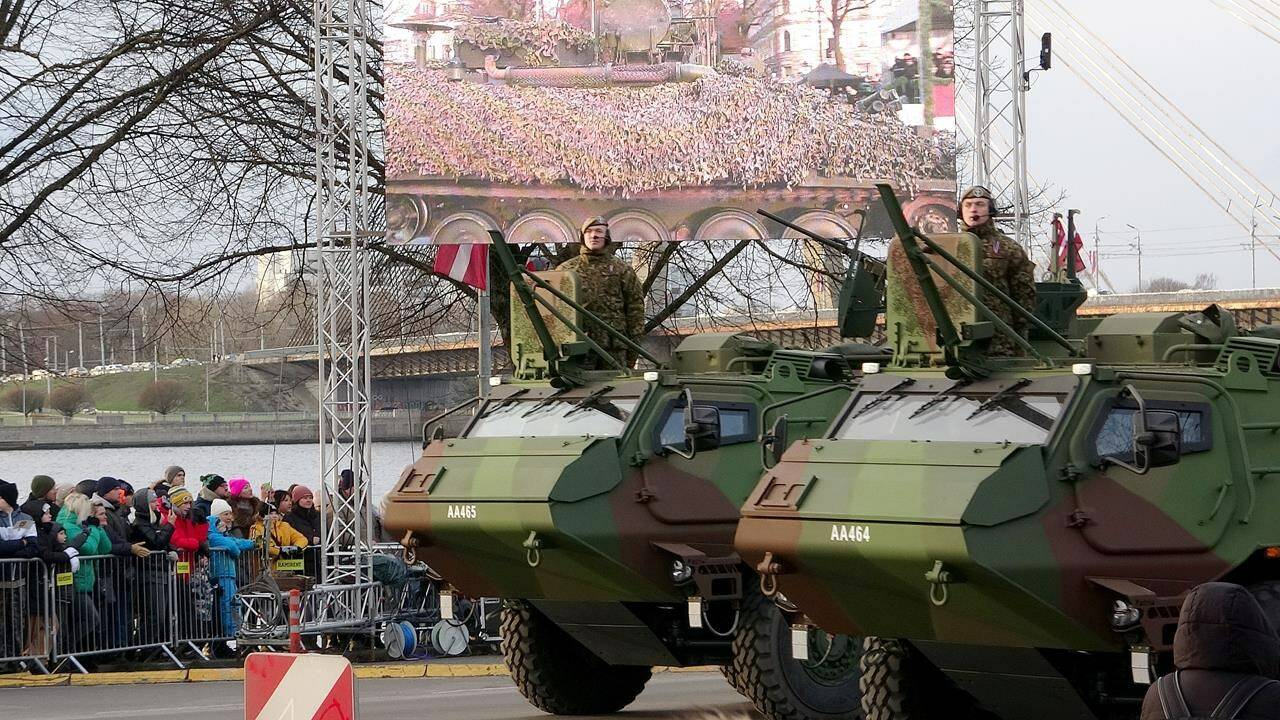 Latvian Army armoured personnel carriers ride during a military parade on Latvian Independence Day, in Riga, Friday, Nov. 18, 2022. Following a strike that killed two people in Poland, a consequence of the war raging in Ukraine, Latvia is reminding its allies that, a little further north, it is also exposed to the Russian threat. THE CANADIAN PRESS/Patrice Bergeron
