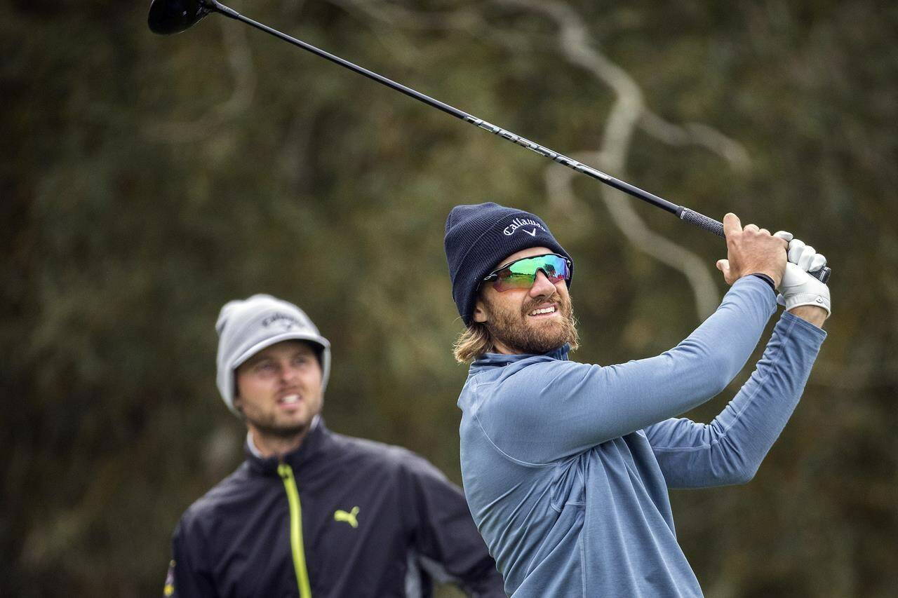 Patrick Rodgers, right, watches his drive down the second fairway along with Adam Svensson, left, of Canada, during the final round of the RSM Classic golf tournament, Sunday, Nov. 20, 2022, in St. Simons Island, Ga. (AP Photo/Stephen B. Morton)