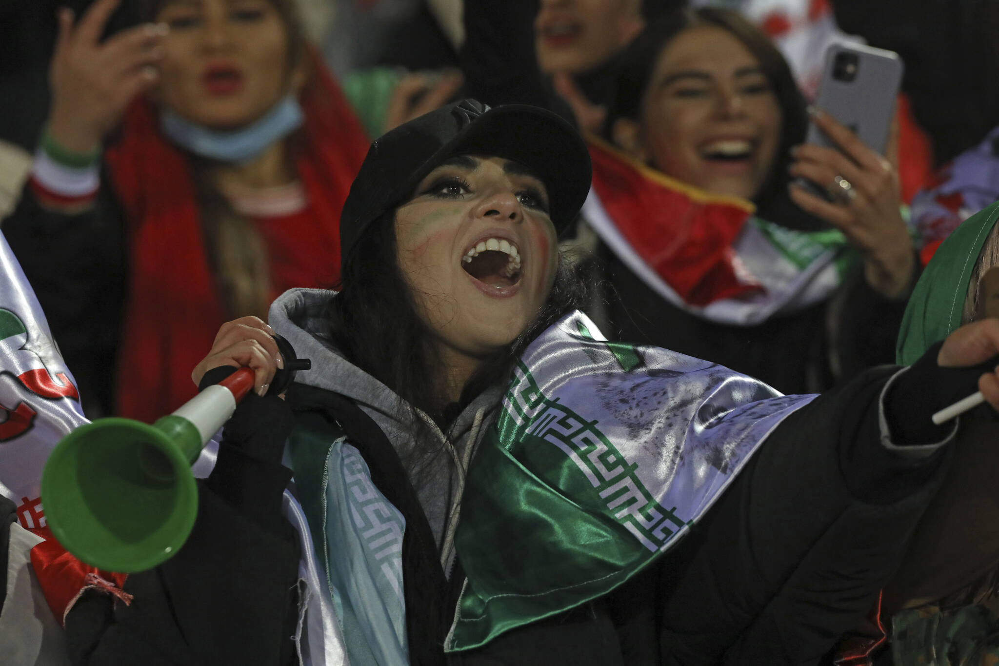 A female Iranian fan cheers after the final whistle during a soccer match of her national team with Iraq in 2022 World Cup qualifiers, at the Azadi stadium in Tehran, Iran, Thursday, Jan. 27, 2022. Iranian authorities allowed women to watch a football match at the stadium as hardliners have long opposed the decision of the government. Iran became the first team from Asia to qualify for this year’s World Cup in Qatar with a 1-0 win over Iraq. (AP Photo/Vahid Salemi)
