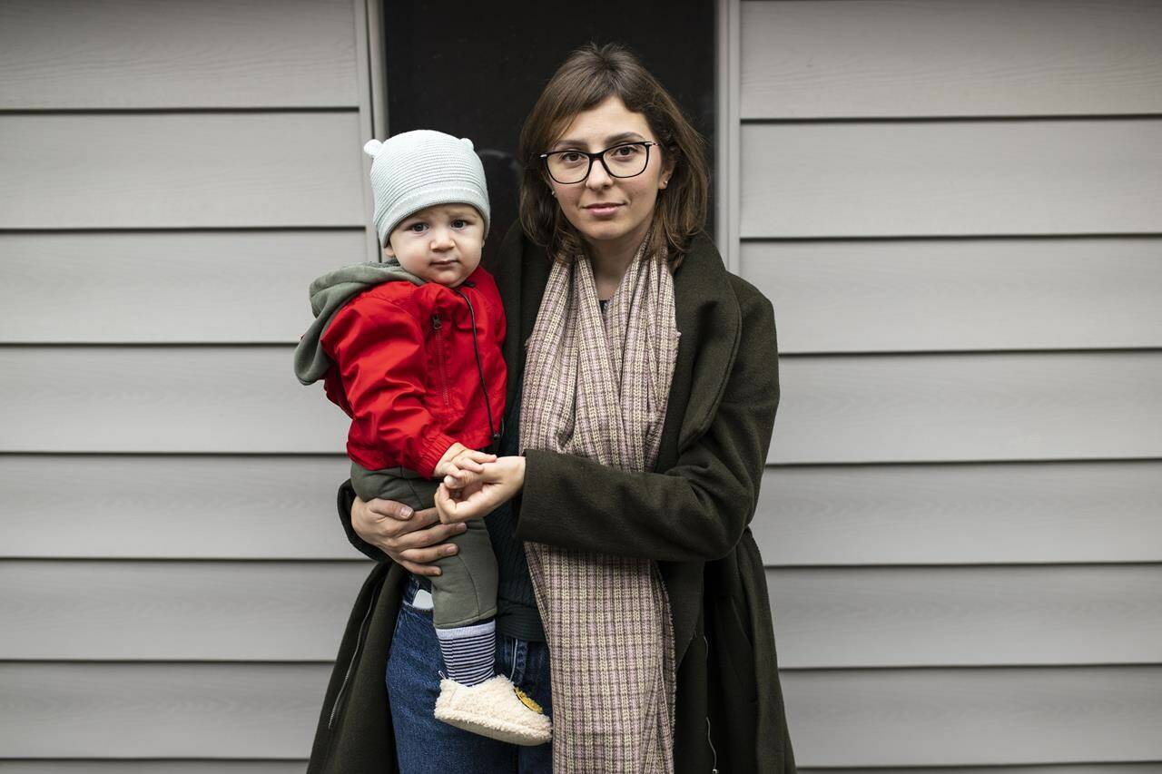 Inna Fomina, who came to Canada to take refuge from the war in Ukraine, stands with her son Adrian Derevianko, 10-month-old, outside their home in Ottawa, on Monday, Oct. 31, 2022. THE CANADIAN PRESS/Justin Tang
