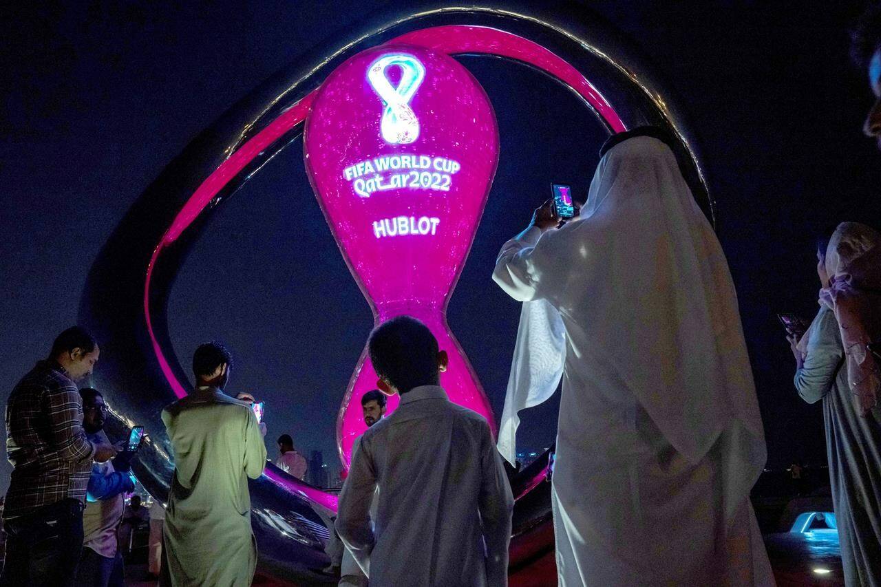 People take photos with the official FIFA World Cup Countdown Clock on Doha’s corniche, in Qatar, Friday, Oct. 14, 2022. Carrie Serwetnyk, the first woman inducted into the Canadian Soccer Hall of Fame, is in Qatar for the 2022 World Cup and says the tournament is “still trying to find its joy.” THE CANADIAN PRESS/AP-Nariman El-Mofty