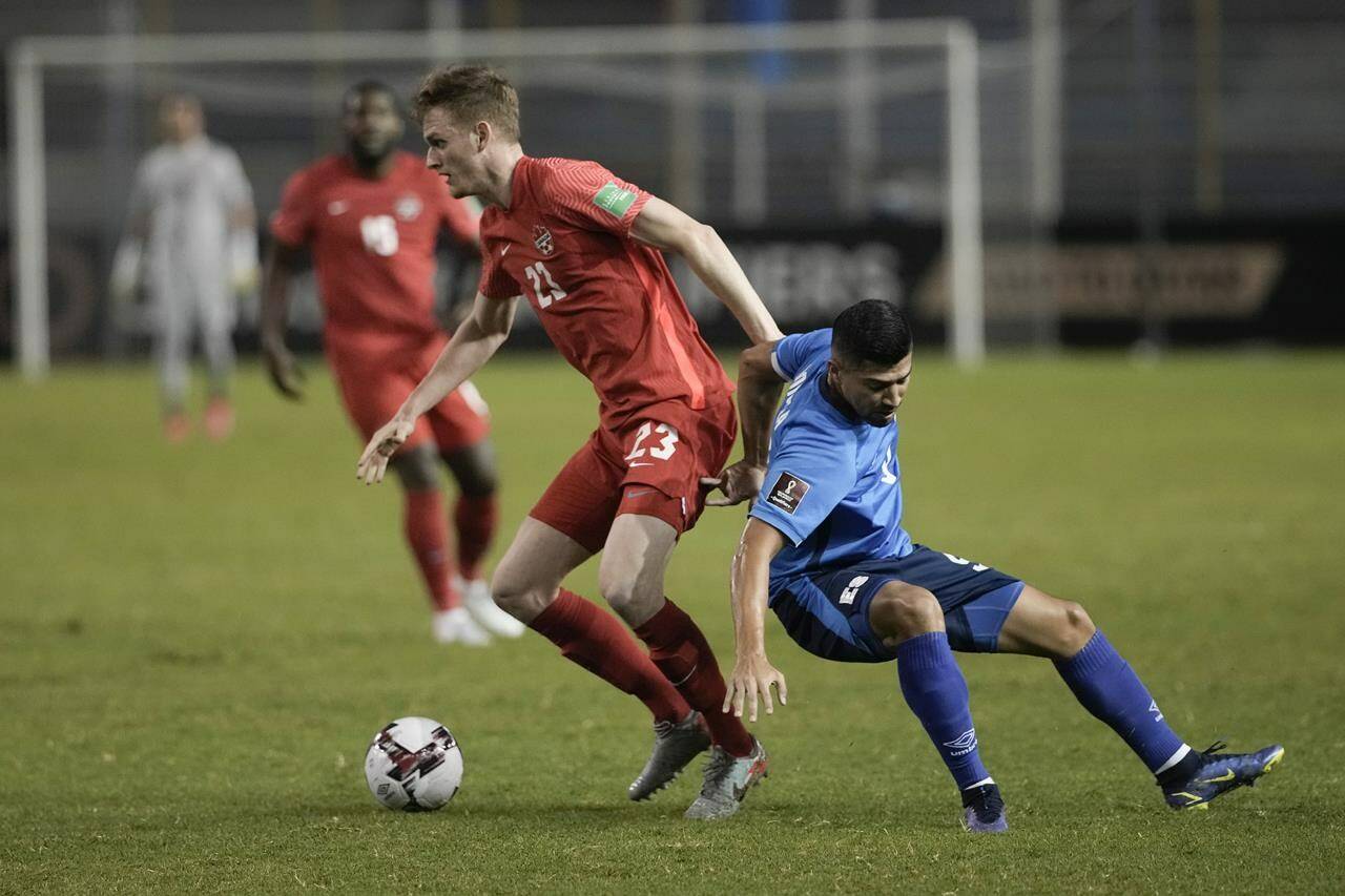 Canada’s Scott Kennedy, left, and El Salvador’s Nelson Bonilla compete for the ball during a qualifying soccer match for the FIFA World Cup Qatar 2022 at Cuscatlan stadium in San Salvador, El Salvador, Wednesday, Feb. 2, 2022. (AP Photo/Moises Castillo)