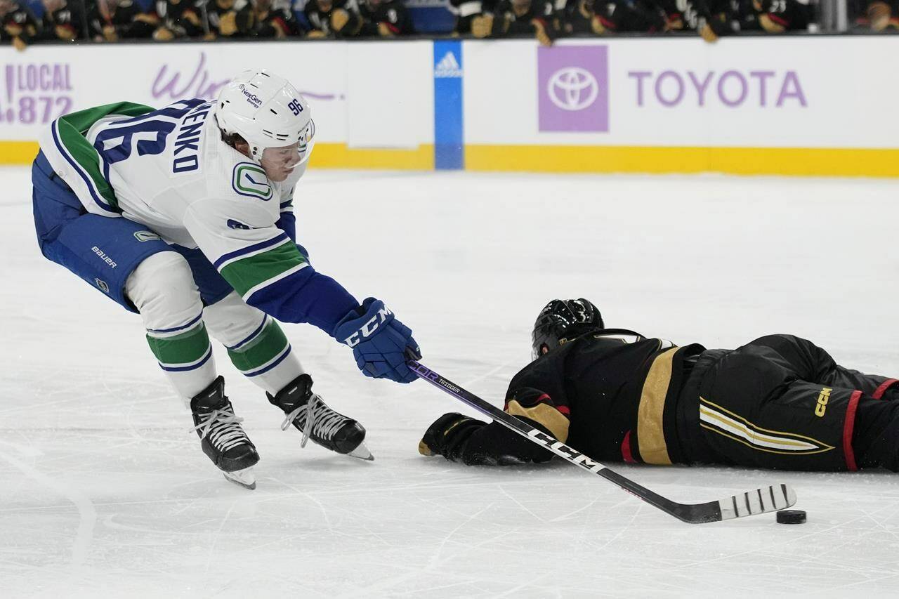 Vancouver Canucks left wing Andrei Kuzmenko (96) attempts a shot around Vegas Golden Knights defenseman Brayden McNabb during the first period of an NHL hockey game Saturday, Nov. 26, 2022, in Las Vegas. (AP Photo/John Locher)