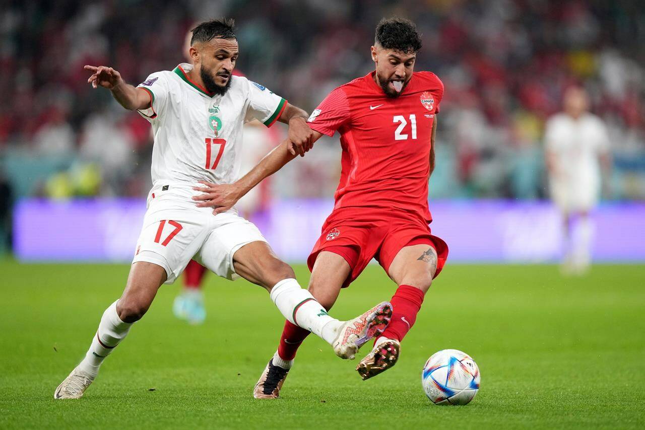Canada midfielder Jonathan Osorio (21) and Morocco midfielder Sofiane Boufal (17) battle for the ball during second half group F World Cup soccer action at the Al Thumama Stadium in Doha, Qatar on Thursday, December 1, 2022. THE CANADIAN PRESS/Nathan Denette