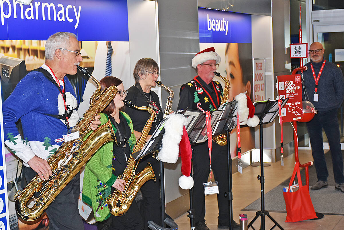 Stuart Richardson (right) watches a saxophone quartet play at ValleyFair Mall in Maple Ridge as bellringers for the Salvation Army. (Neil Corbett/The News)
