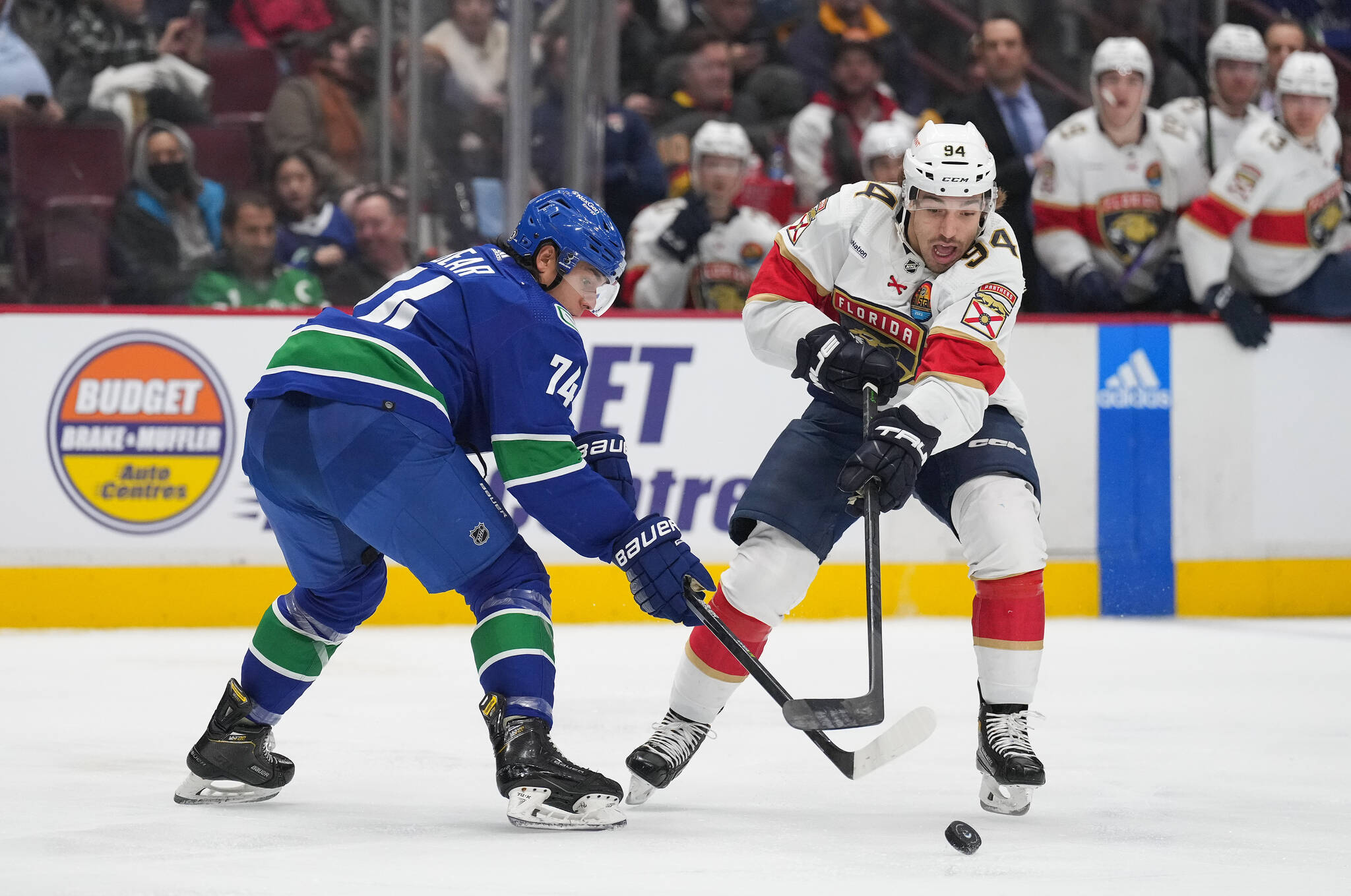 Vancouver Canucks’ Ethan Bear, left, and Florida Panthers’ Ryan Lomberg vie for the puck during the second period of an NHL hockey game in Vancouver, on Thursday, December 1, 2022. THE CANADIAN PRESS/Darryl Dyck