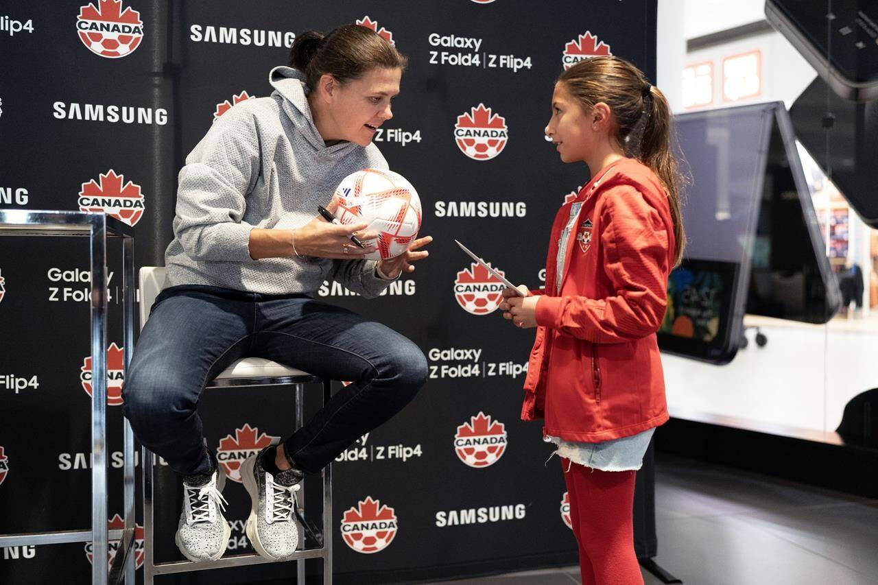 Canadian soccer star Christine Sinclair autographs a fan’s ball at a World Cup watch party in Toronto on Wednesday, Nov. 23, 2022. Sinclair is serving as an adviser to Project 8 Sports Inc., a new pro women’s soccer league planned to kick off in Canada in 2025. THE CANADIAN PRESS/Arlyn McAdorey
