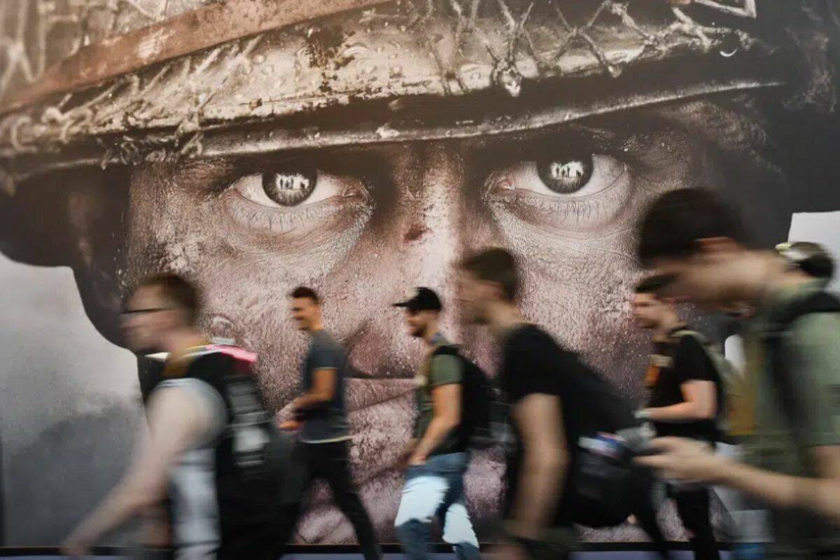 FILE - Visitors passing an advertisement for the video game 'Call of Duty' at the Gamescom fair for computer games in Cologne, Germany, Tuesday, Aug. 22, 2017. Microsoft says it struck a deal to make the hit video game Call of Duty available on Nintendo for 10 years when its $69 billion purchase of game maker Activision Blizzard goes through. The announcement Wednesday, Dec. 7, 2022 is an apparent attempt to fend off objections from rival Sony. (AP Photo/Martin Meissner, File)