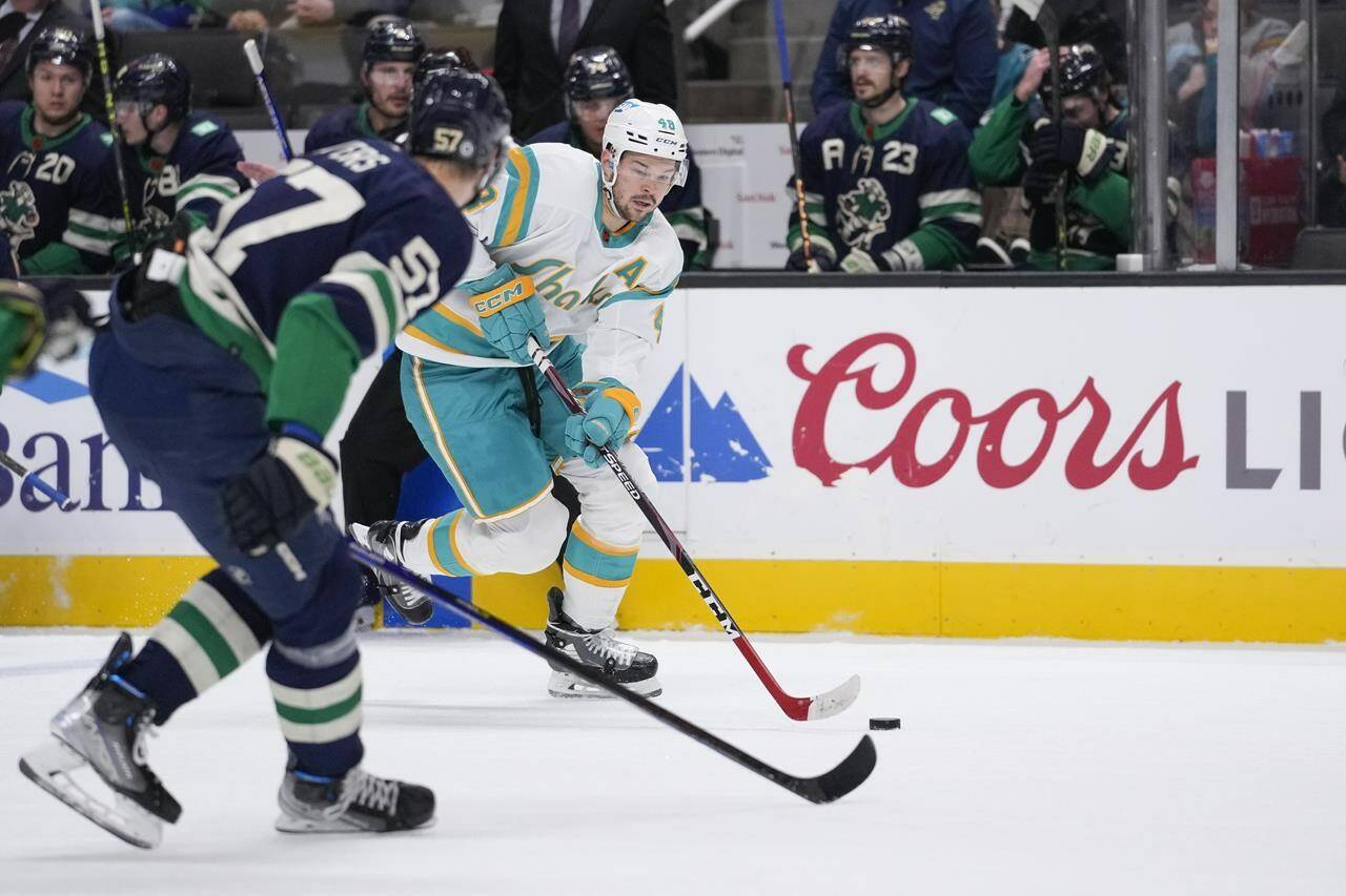 San Jose Sharks centre Tomas Hertl (48) looks to pass while defended by Vancouver Canucks defenceman Tyler Myers (57) during the first period of an NHL hockey game in San Jose, Calif., Wednesday, Dec. 7, 2022. (AP Photo/Godofredo A. Vásquez)