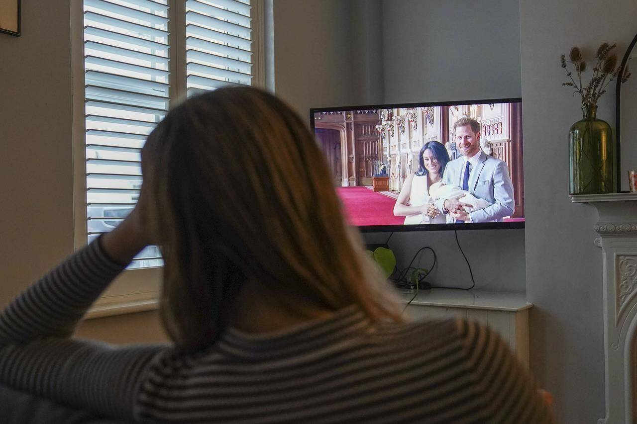 Georgia watches the Duke and Duchess of Sussex’s controversial documentary being aired on Netflix at her home in Warwick, Britain, Thursday, Dec. 8, 2022. Britain’s monarchy is bracing for more bombshells to be lobbed over the palace gates as Netflix releases the first three episodes of a new series. The show “Harry & Meghan” promises to tell the “full truth” about Prince Harry and his wife Meghan’s estrangement from the royal family. The series debuted Thursday. (Jacob King/PA via AP)