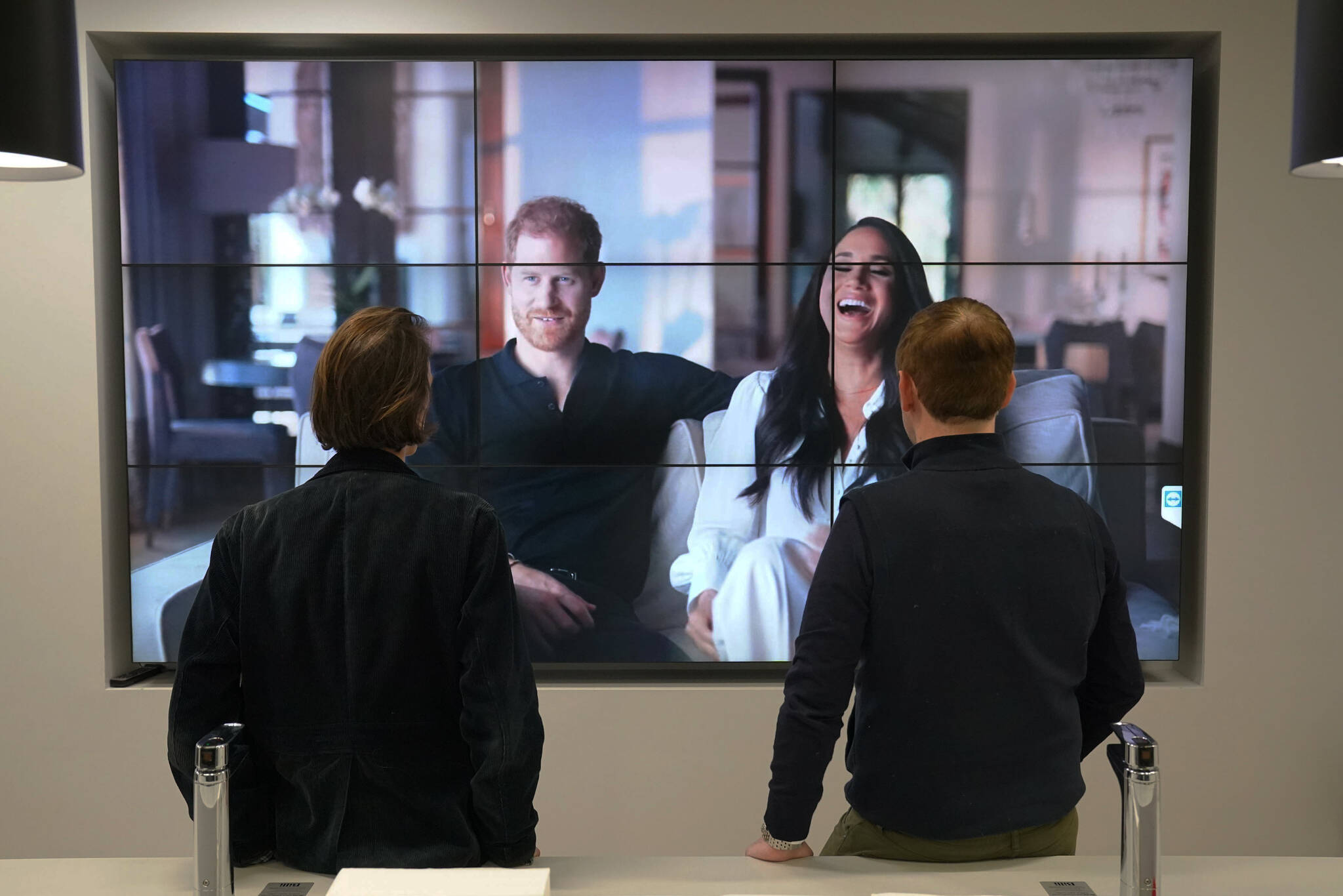 Office workers in London, watch the Duke and Duchess of Sussex’s controversial documentary being aired on Netflix Thursday, Dec. 8, 2022. Britain’s monarchy is bracing for more bombshells to be lobbed over the palace gates as Netflix releases the first three episodes of a new series. The show ‘Harry & Meghan’ promises to tell the ‘full truth’ about Prince Harry and his wife Meghan’s estrangement from the royal family. The series debuted Thursday. (Jonathan Brady/PA via AP)