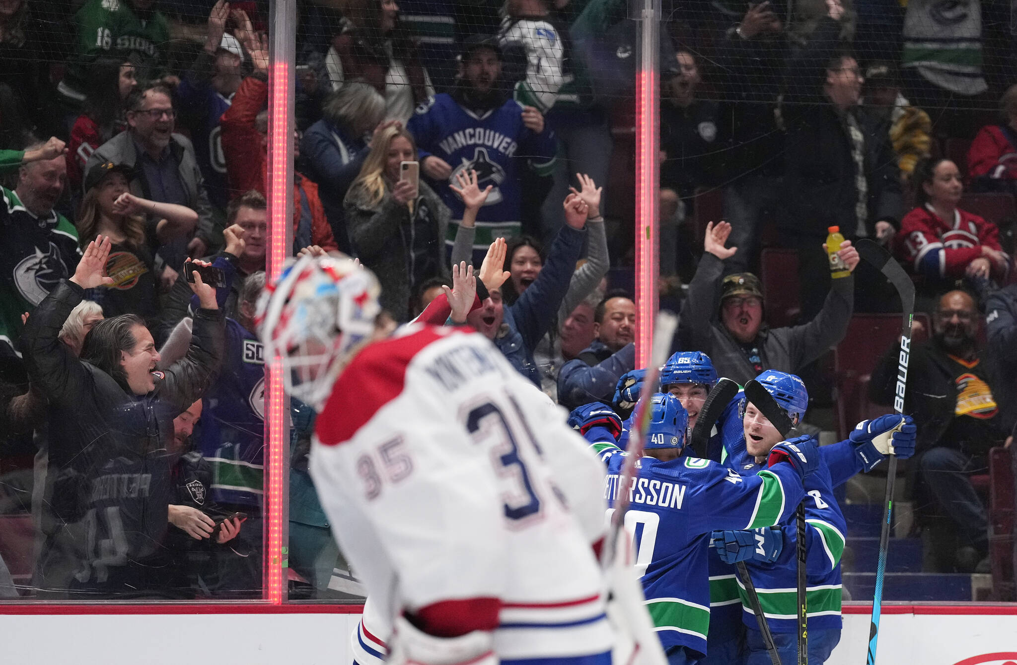 Vancouver Canucks’ Ilya Mikheyev, back, of Russia, Brock Boeser, back right, and Elias Pettersson celebrate Mikheyev’s goal against Montreal Canadiens goalie Sam Montembeault during the third period of an NHL hockey game in Vancouver, B.C., Monday, Dec. 5, 2022. THE CANADIAN PRESS/Darryl Dyck