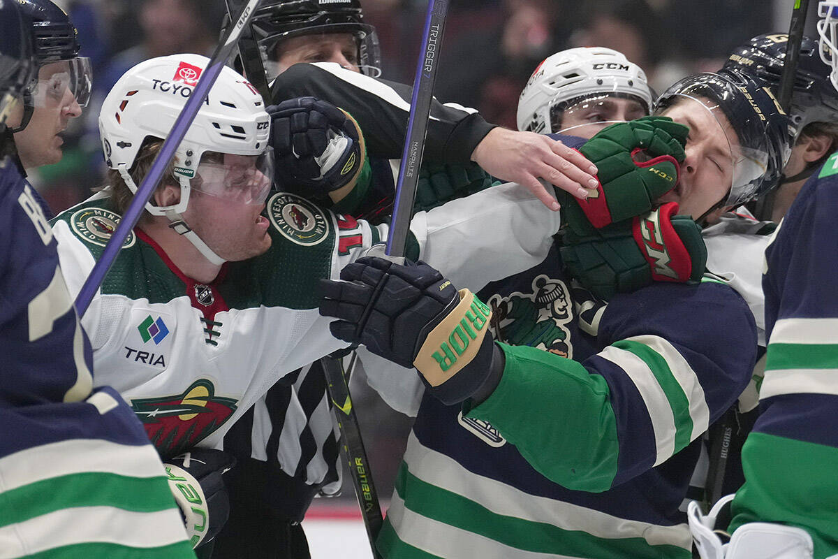 Minnesota Wild’s Mason Shaw, left, and Vancouver Canucks’ Curtis Lazar get into a scuffle during the first period of an NHL hockey game in Vancouver, on Saturday, December 10, 2022. THE CANADIAN PRESS/Darryl Dyck