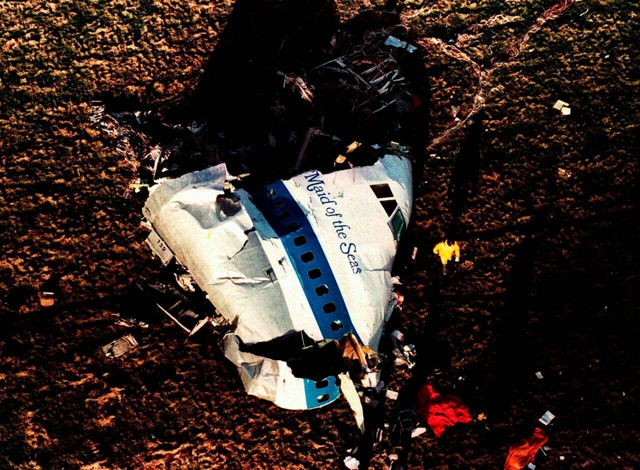 FILE Police and investigators look at what remains of the nose of Pan Am 103 in a field in Lockerbie, Scotland, in this Dec. 22, 1988 file photo. U.S. and Scottish authorities said Sunday, Dec. 11, 2022 that the Libyan man suspected of making the bomb that destroyed a passenger plane over Lockerbie, Scotland, in 1988 is in U.S. custody. (AP Photo/Martin Cleaver, File)