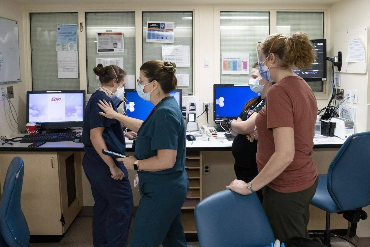 Registered nurse Lee-Anne Williams, centre, confers with colleagues in the intensive care unit at Toronto’s Hospital for Sick Children on Wednesday, Nov. 30, 2022. THE CANADIAN PRESS/Chris Young