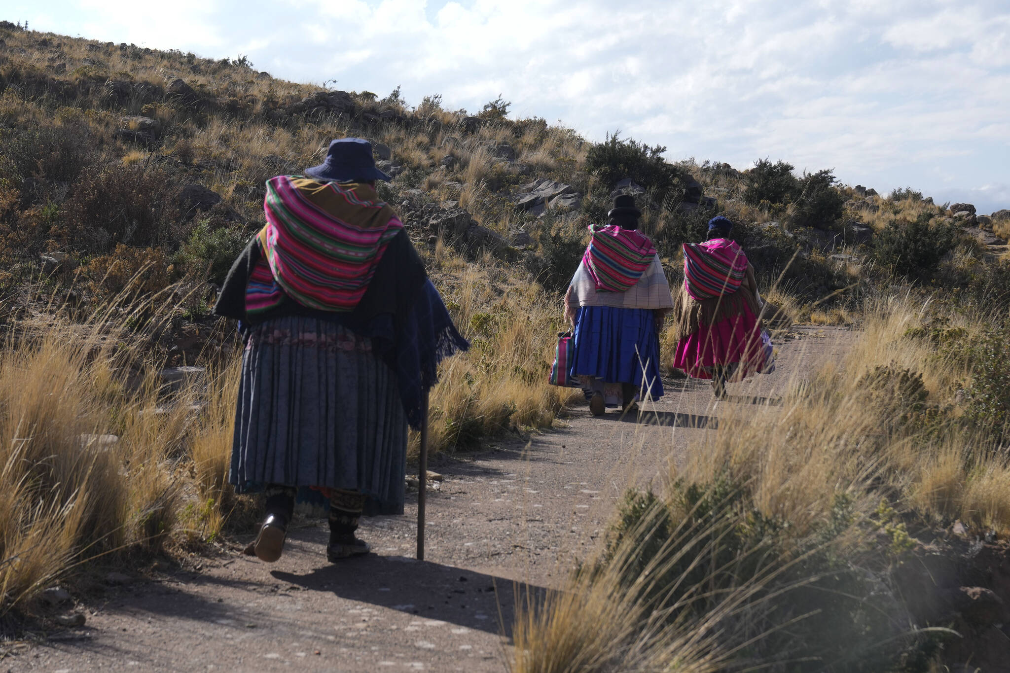 Indigenous Aymara women walk to the sacred mountain Inca Pucara for a day of prayer and fasting in a call for rain in Chiquipata, Bolivia, Wednesday, Nov. 16, 2022. Residents in the highlands of La Paz say the lack of rain and frost since September is not allowing them to plant potatoes, beans, carrots and peas. (AP Photo/Juan Karita)