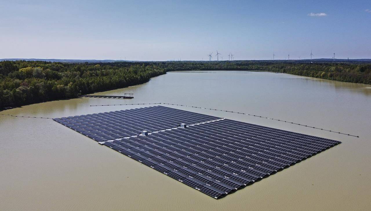 File - Solar panels on Germany’s biggest floating photovoltaic plant produce energy under a blue sky on a lake in Haltern, Germany, on May 3, 2022. The heads of the International Energy Agency and European Union’s executive branch said Monday Dec. 12, 2022 that the 27-nation bloc is expected to weather an energy crisis this winter but needs to speed renewables to the market and take other steps to avoid a potential shortage next year in natural gas needed for heating, electricity and factories. (AP Photo/Martin Meissner, File)