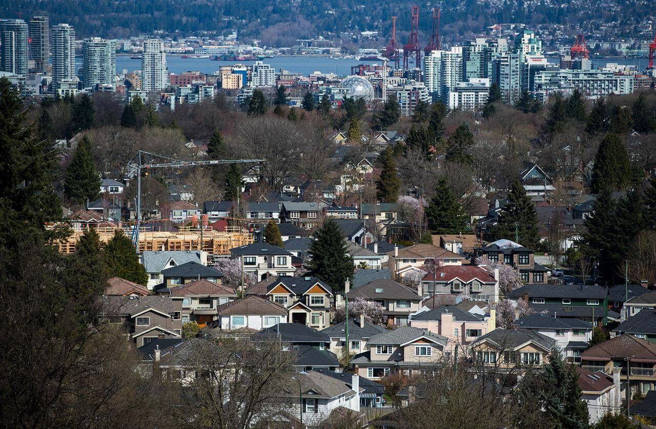 A condo building is seen under construction surrounded by houses as condo towers are seen in the distance in Vancouver, B.C., on Friday March 30, 2018. Vancouver has the most expensive rent in Canada with the average price of a one-bedroom going for $2,633 per month in November. THE CANADIAN PRESS/Darryl Dyck