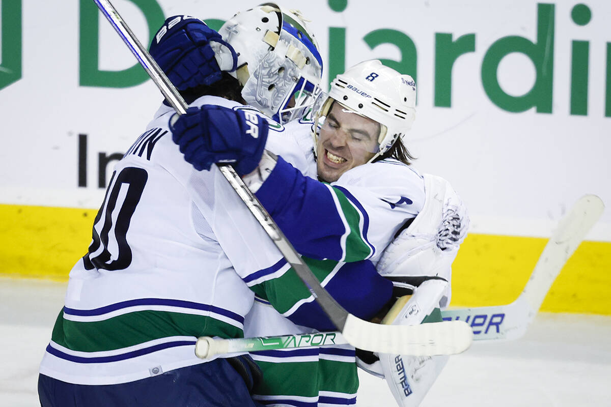 Vancouver Canucks goalie Spencer Martin, left, and forward Conor Garland celebrate defeating the Calgary Flames in a shootout during NHL hockey action in Calgary, Wednesday, Dec. 14, 2022.THE CANADIAN PRESS/Jeff McIntosh
