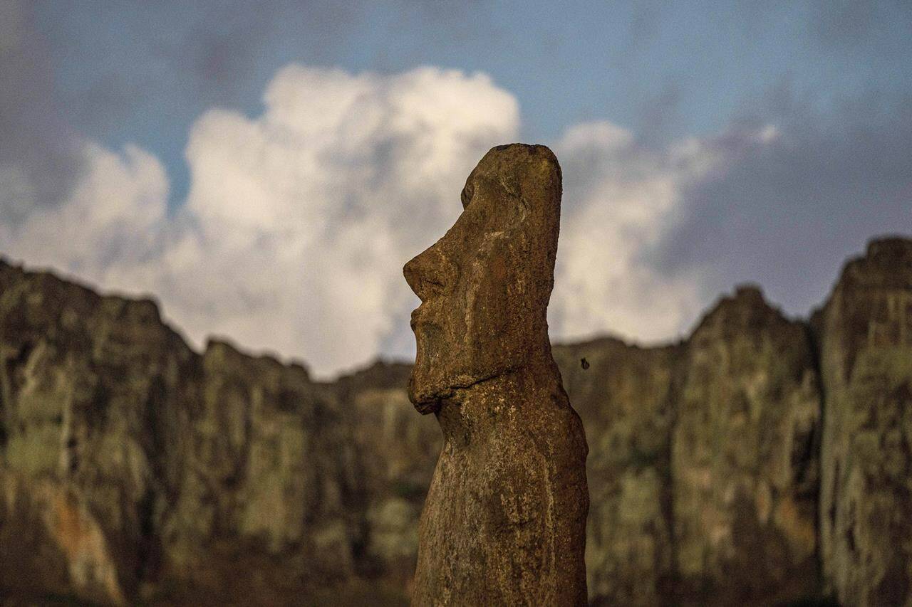 A moai stands behind the Rano Raraku volcano on Ahu Tongariki, Rapa Nui, or Easter Island, Chile, Monday, Nov. 28, 2022. Each monolithic human figure carved centuries ago by this remote Pacific island’s Rapanui people represents an ancestor. (AP Photo/Esteban Felix)