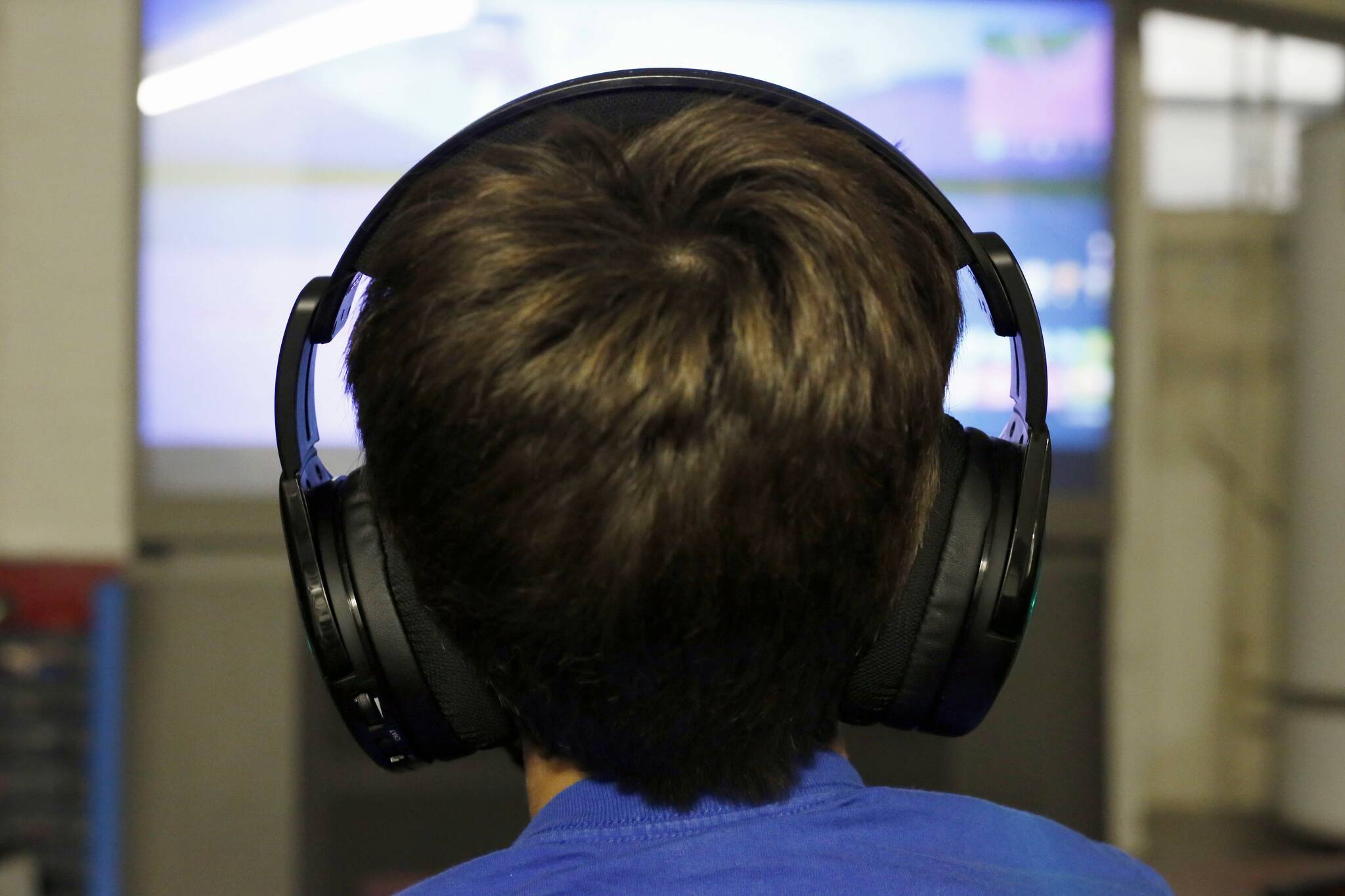 FILE- In this Oct. 6, 2018, file photo Henry Hailey, 10, plays one of the online “Fortnite” game in the early morning hours in the basement of his Chicago home. (AP Photo/Martha Irvine, File)