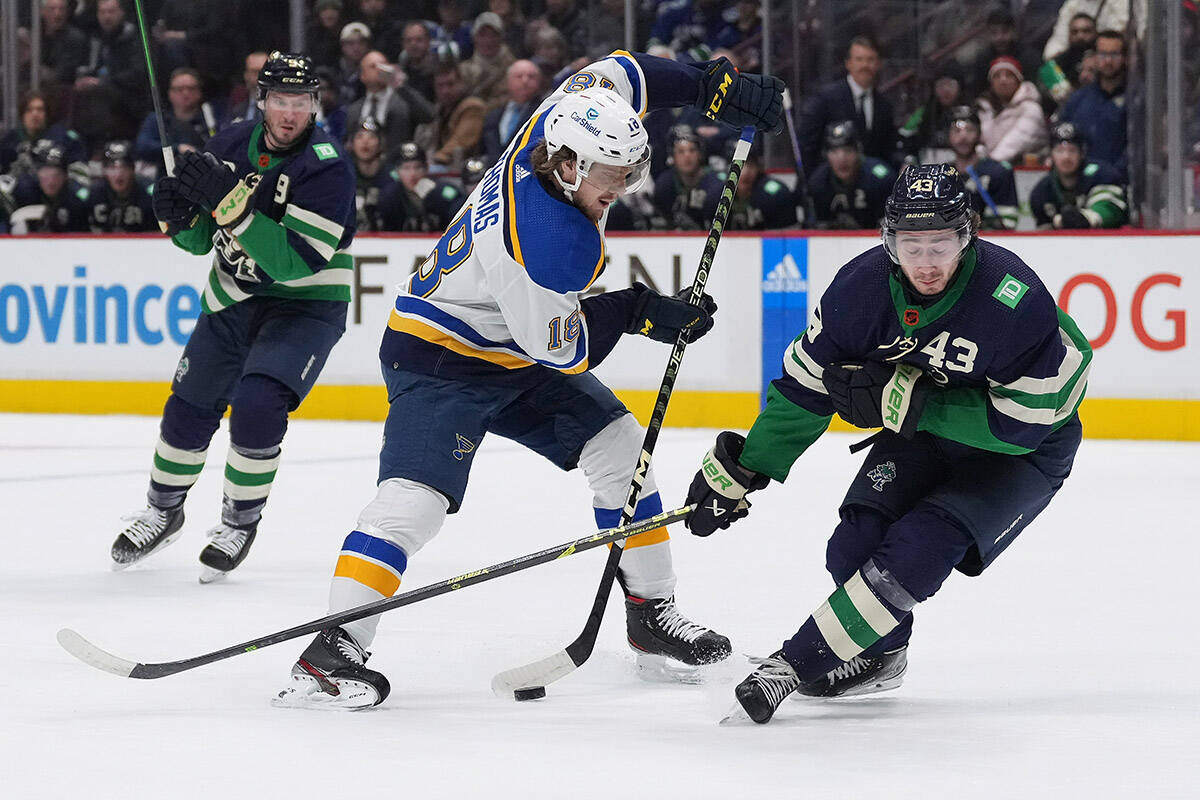 St. Louis Blues’ Robert Thomas (18) stickhandles past Vancouver Canucks’ Quinn Hughes (43) during the first period of an NHL hockey game in Vancouver, on Monday, December 19, 2022. THE CANADIAN PRESS/Darryl Dyck