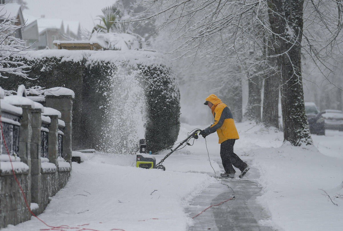 A man uses a snowblower to clear snow from a sidewalk in Vancouver, on Sunday, December 18, 2022. Temperature are dropping to dangerously cold extremes in some regions of British Columbia as snowfall send tires spinning in parts of Metro Vancouver. Environment Canada says wind chill values are dropping near -40 C or colder in the Chilcotin, Cariboo, Prince George and other central B.C. communities. THE CANADIAN PRESS/Darryl Dyck