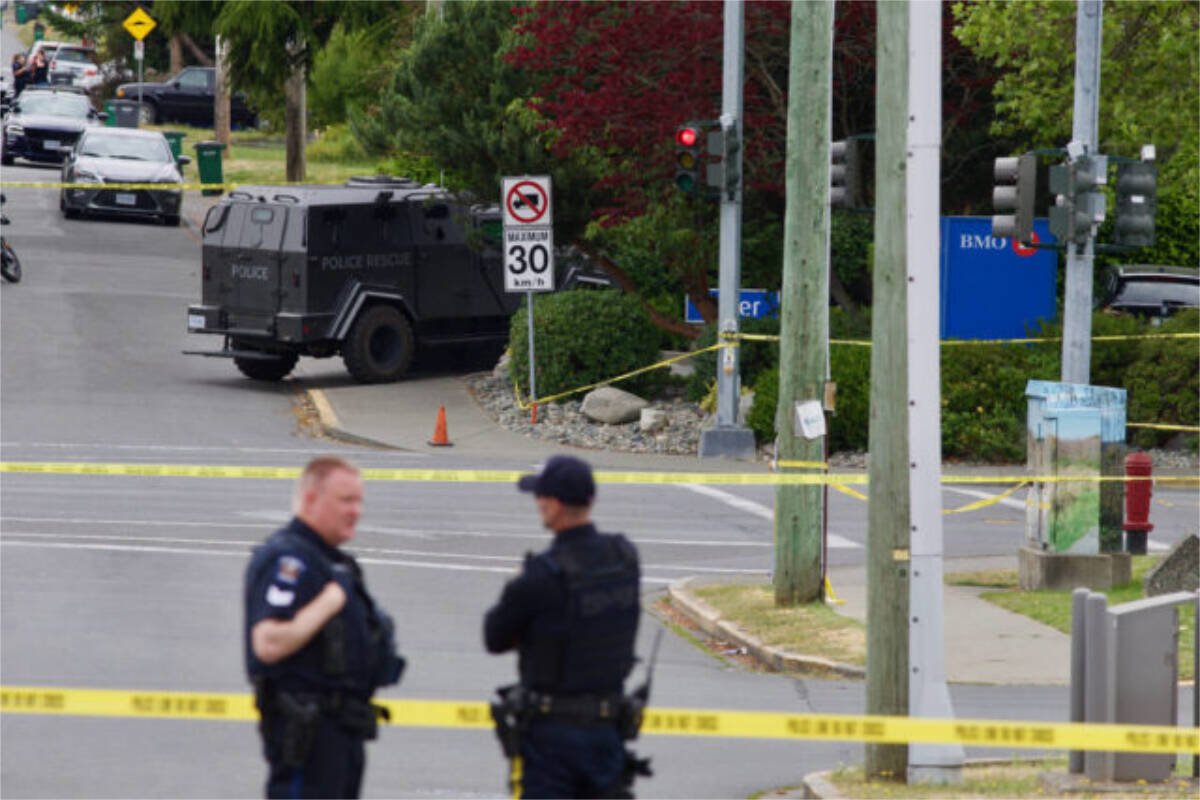 Police stand watch over the scene of a bank robbery in Saanich which left two suspects dead and six police officers injured. (Black Press Media file photo)