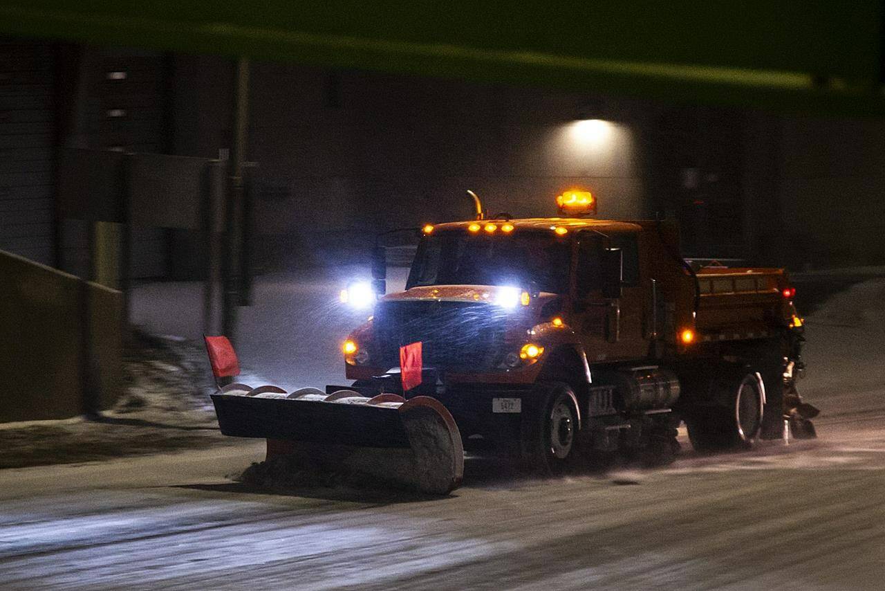 An Iowa Department of Transportation (IDOT) plow drives along Riverside Drive as snow falls during a blizzard warning, Wednesday, Dec. 21, 2022, in Iowa City, Iowa. (Joseph Cress/Iowa City Press-Citizen via AP)