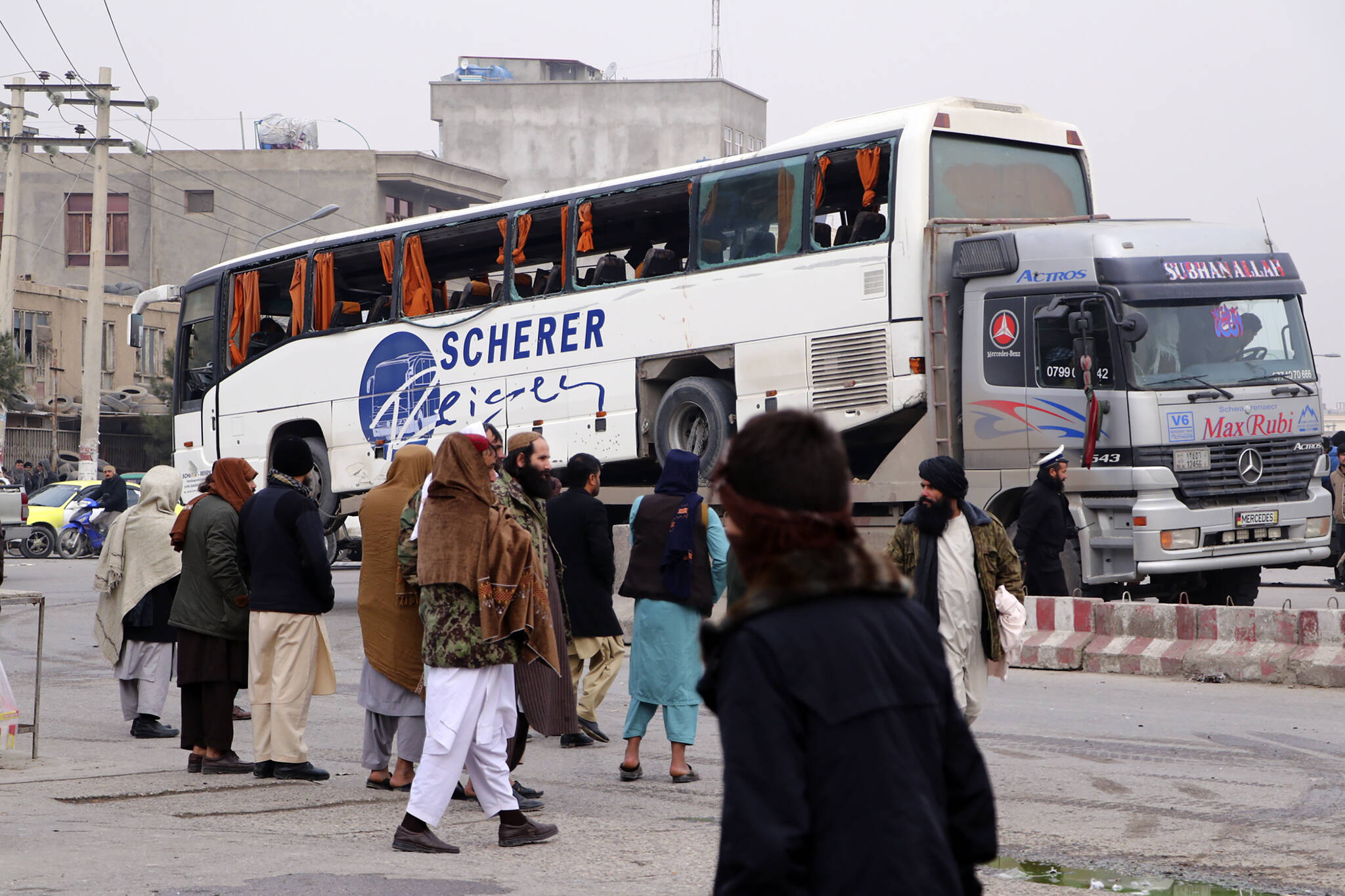Taliban security personnel carry a damaged bus after a roadside bomb blast in Mazar-e Sharif, the capital city of Balkh province, in northern Afghanistan, Tuesday, Dec. 6, 2022. A Taliban official says that a roadside bomb went off near a government bus in northern Afghanistan, killing several people. (AP Photo)
