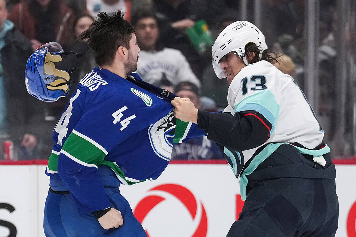 Vancouver Canucks’ Kyle Burroughs (44) and Seattle Kraken’s Brandon Tanev (13) fight during the second period of an NHL hockey game in Vancouver, on Thursday, December 22, 2022. THE CANADIAN PRESS/Darryl Dyck