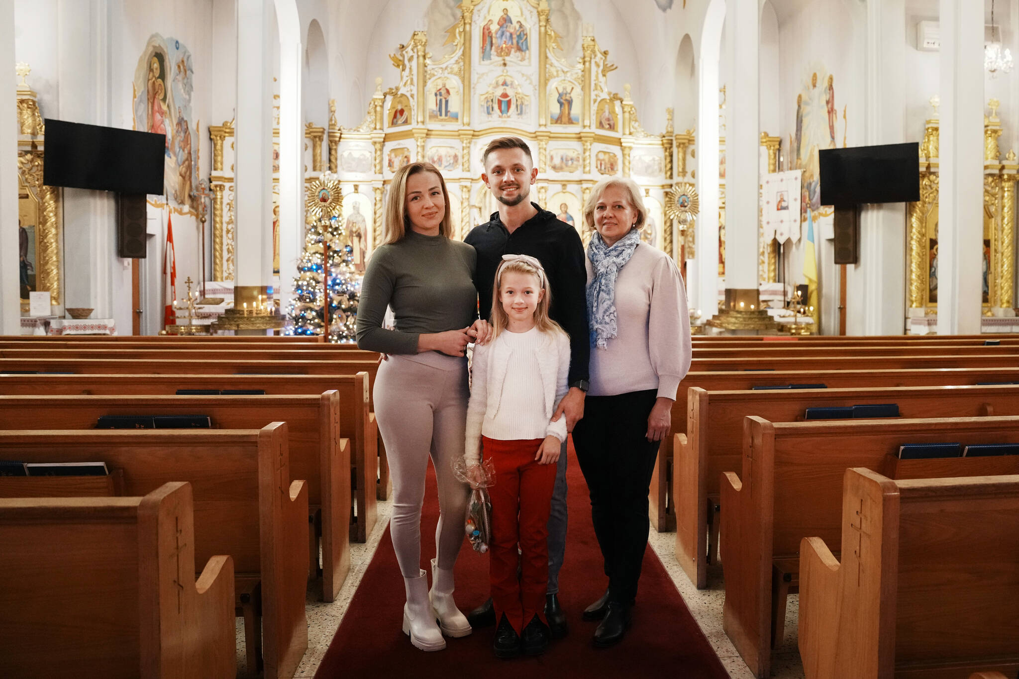 Vitali Hrechka poses for a photo with his wife Evelina, daughter Emiliia, and mother Hanna, after the St. Nicholas Day celebration at St. Demetrius Ukrainian Orthodox Church in Toronto on Sunday, Dec. 18, 2022. The family recently arrived in Canada after leaving their home in Ukraine’s Transkarpathia region. THE CANADIAN PRESS/Chris Young