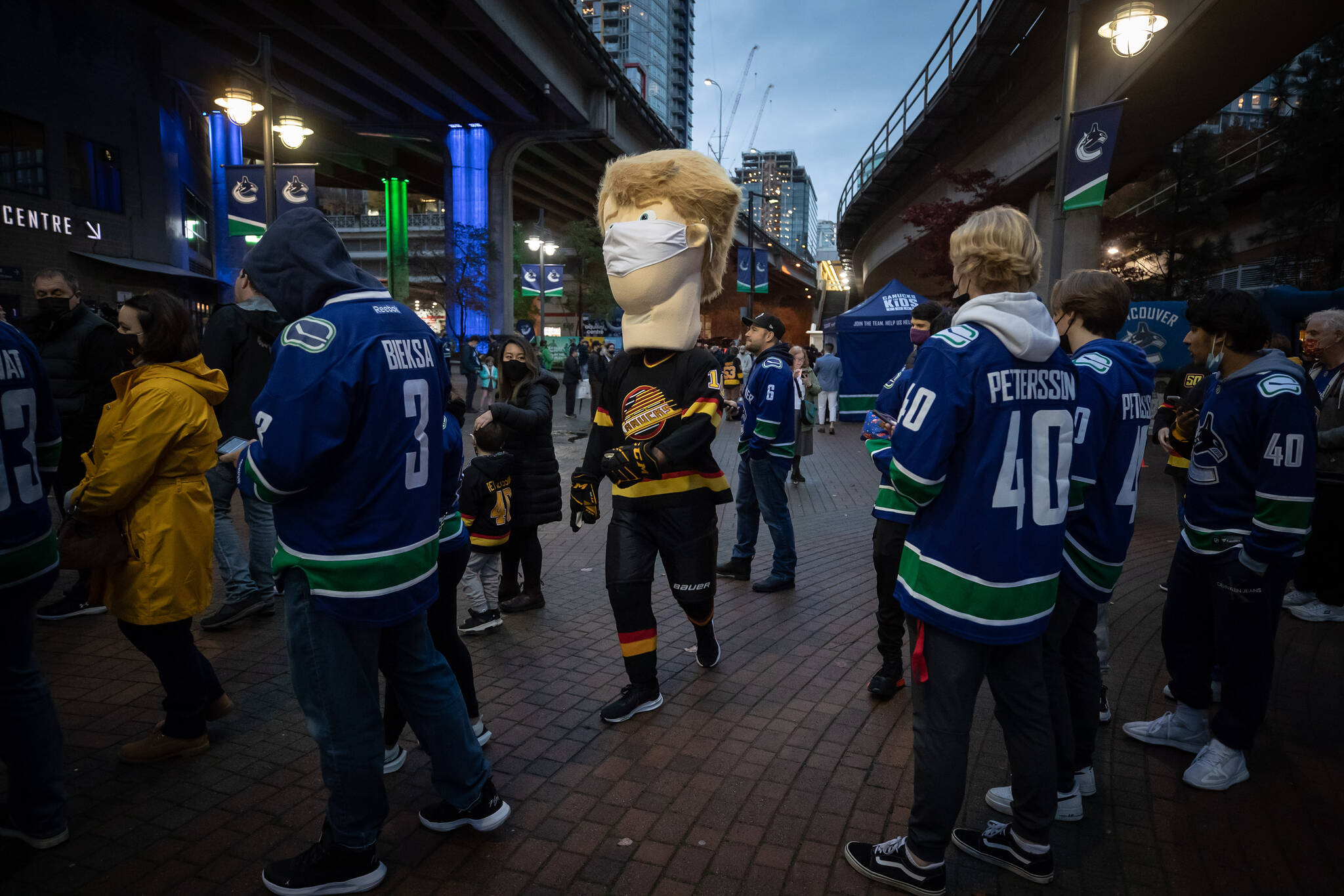 A Pavel Bure mascot wearing a face mask walks through the crowd as fans wait to enter Rogers Arena for the Vancouver Canucks NHL hockey game against the Minnesota Wild in Vancouver, on Tuesday, October 26, 2021. THE CANADIAN PRESS/Darryl Dyck