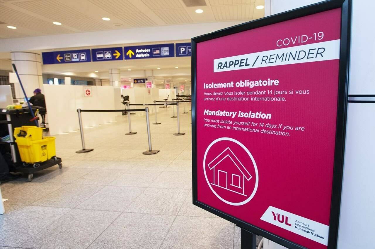 A sign reminds arriving passengers to quarantine against COVID-19 at Trudeau Airport in Montreal, Friday, Feb. 19, 2021. THE CANADIAN PRESS/Ryan Remiorz