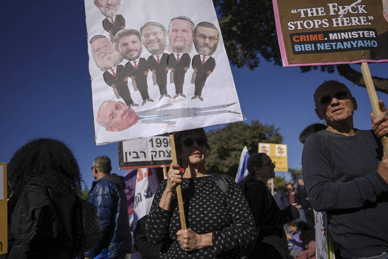 Protesters hold banners against Benjamin Netanyahu’s new government in front of Israel’s Parliament in Jerusalem, Thursday, Dec. 29, 2022. Netanyahu was set to return to office Thursday at the helm of the most religious and ultranationalist government in Israel’s history, vowing to implement policies that could cause domestic and regional turmoil and alienate the country’s closest allies. (AP Photo/Oded Balilty)