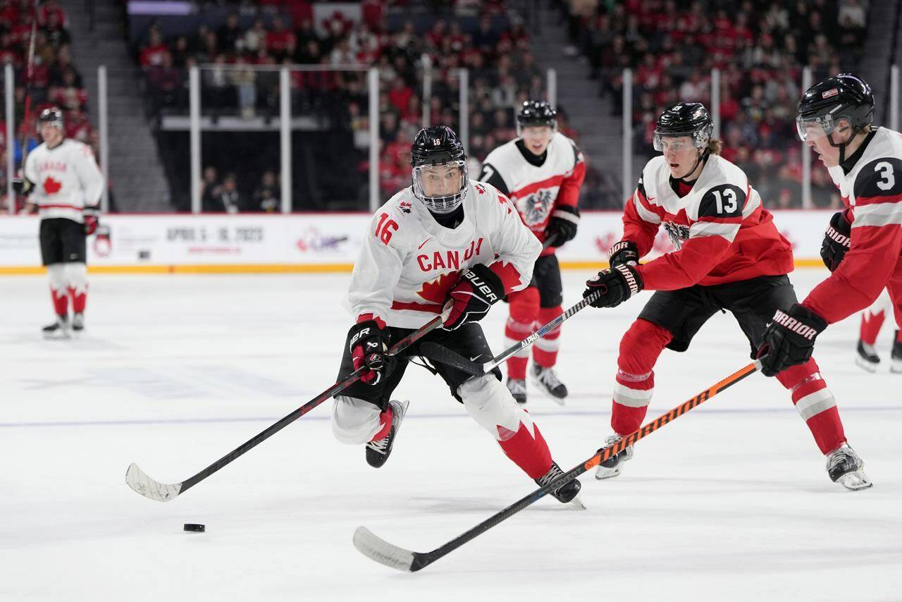 Canada’s Connor Bedard, left, skates past Austria’s Lukas Horl, right, and Luca Auer during second period IIHF World Junior Hockey Championship action in Halifax on Thursday, December 29, 2022. THE CANADIAN PRESS/Darren Calabrese