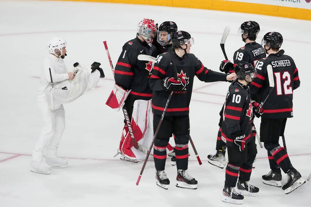 Camera operator Nathan Eides, left, records Canada celebrating a win over Sweden during IIHF World Junior Hockey Championship action in Halifax on Saturday, December 31, 2022. THE CANADIAN PRESS/Darren Calabrese