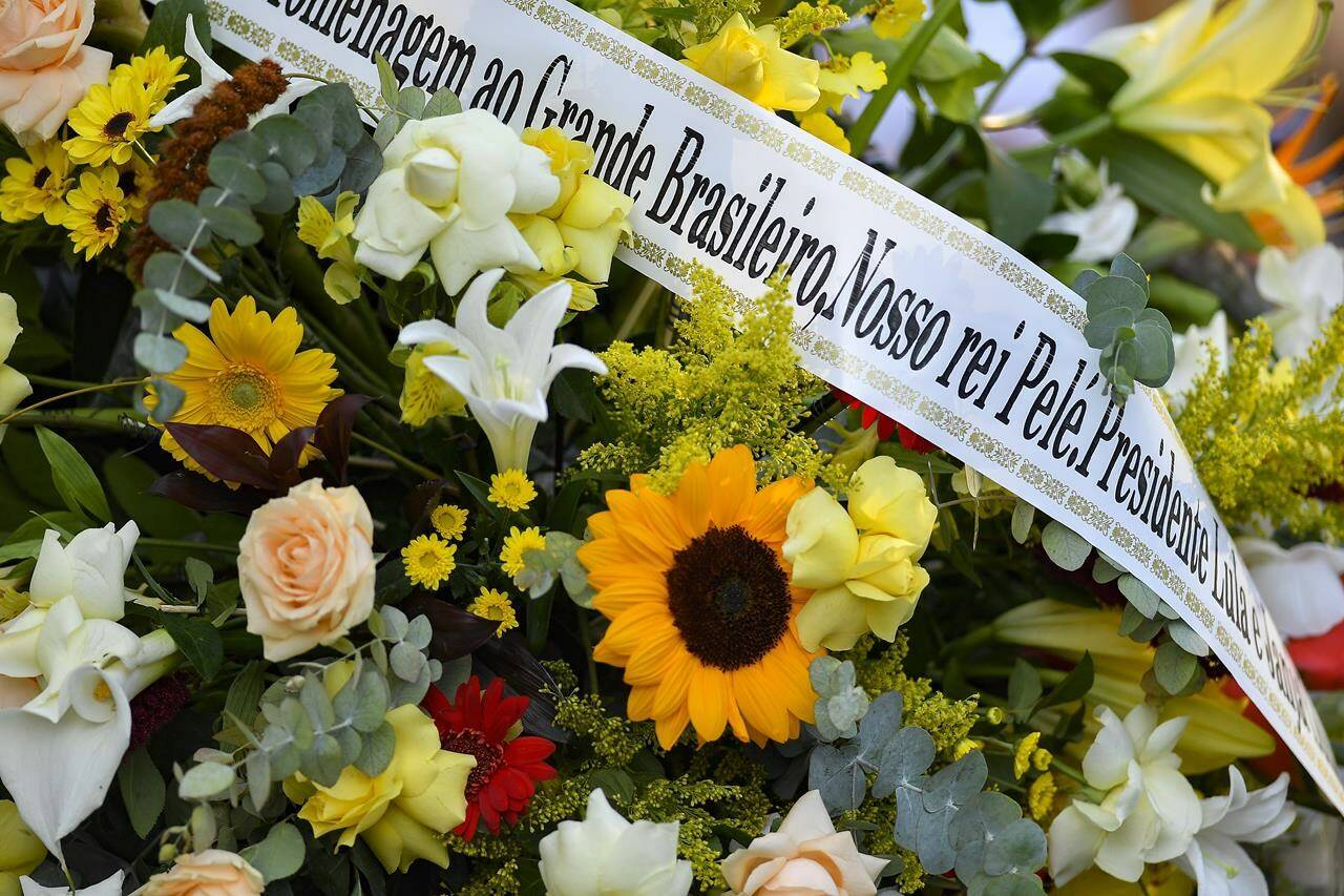 A flower arrangement sent by Brazilian President Luiz Inacio Lula da Silva lays arrive for the wake of late Brazilian soccer great Pele as he lies instate at Vila Belmiro stadium in Santos, Brazil, Monday, Jan. 2, 2023. (AP Photo/Matias Delacroix)