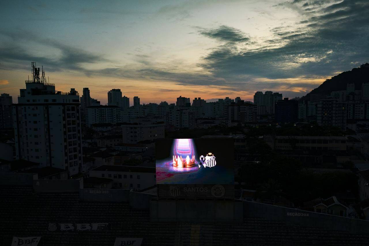 A crown displayed on a TV screen at Vila Belmiro stadium where Pele, the late Brazilian soccer great lies in state in Santos, Brazil, Monday, Jan. 2, 2023. (AP Photo/Matias Delacroix)