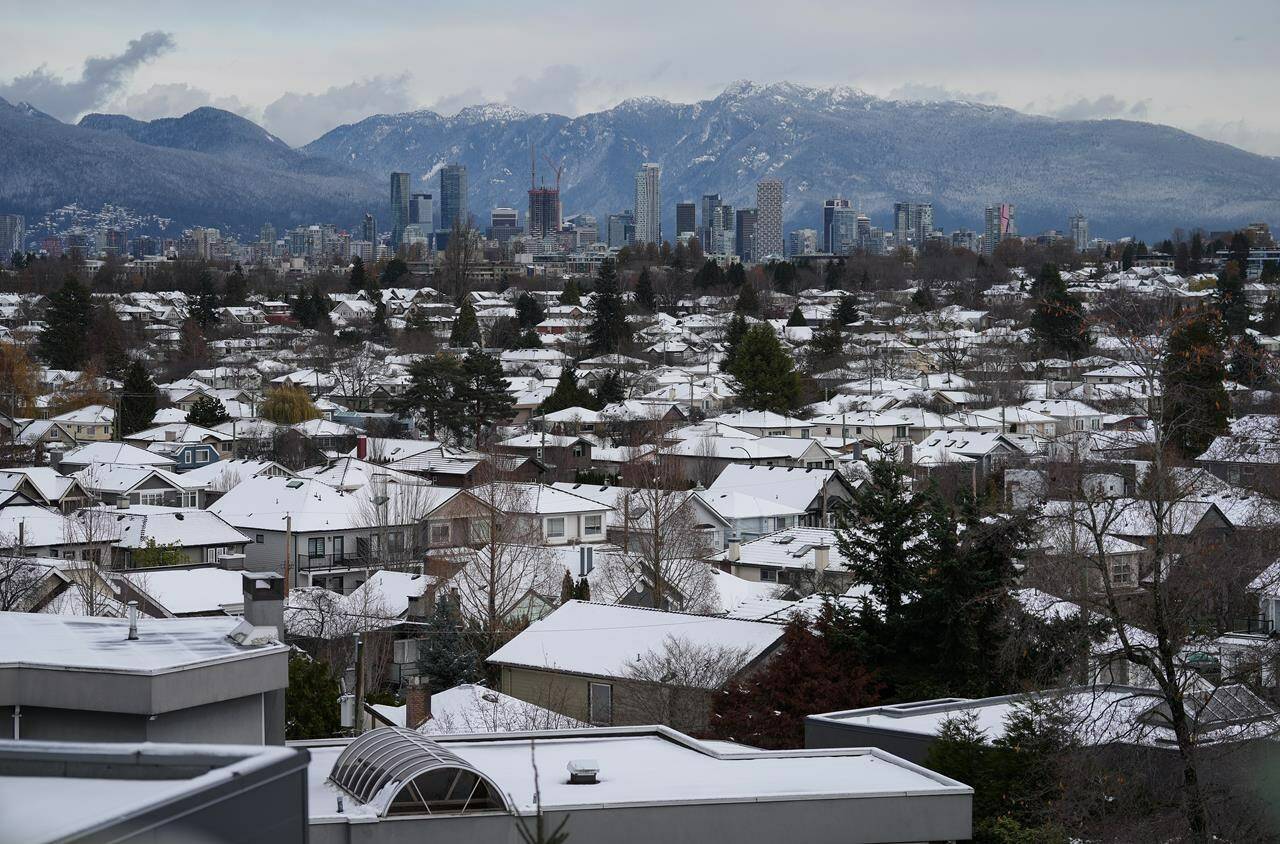 Snow-covered houses and the downtown skyline are seen in Vancouver, B.C., Wednesday, Nov. 30, 2022.The British Columbia government is boosting the homeowner grant threshold to $2.125 million for this year as average property values increase by 12 per cent.THE CANADIAN PRESS/Darryl Dyck