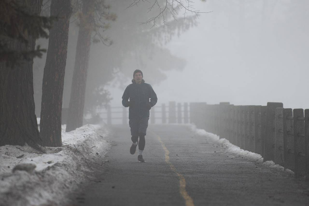 A person jogs along the Rideau Canal in Ottawa, on Saturday, Dec. 31, 2022. One extreme weather expert says the current spell of mild winter temperatures felt in Ontario are becoming more frequent across Canada due to climate change. THE CANADIAN PRESS/Spencer Colby