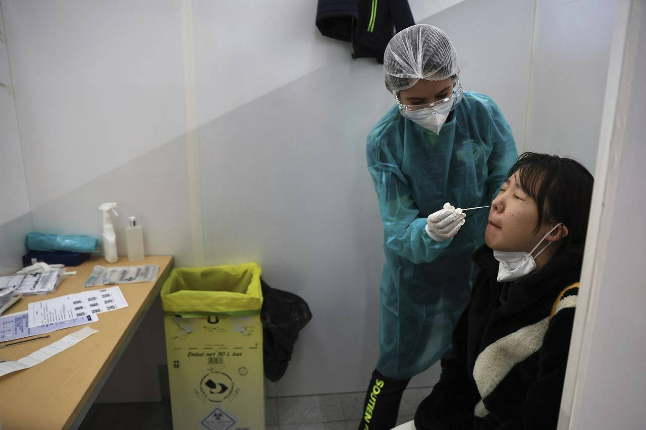 FILE - A passenger arriving from China is tested for COVID-19 at the Roissy Charles de Gaulle airport, north of Paris, Sunday, Jan. 1, 2023. European Union nations are fine-tuning a coordinated response to China’s COVID-19 crisis on Wednesday, Jan. 4, 2023 and are zeroing in on travel restrictions that would upset both Beijing and the global airline industry. (AP Photo/Aurelien Morissard, File)